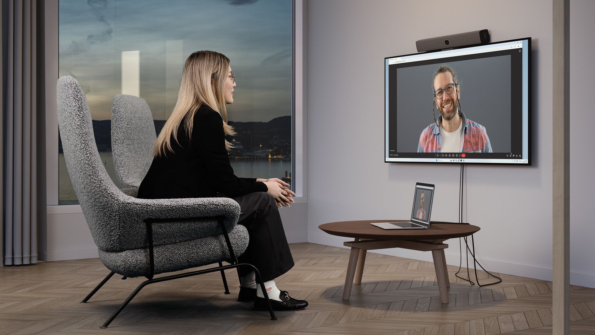 A focus space set for a one-to-one call: a single armchair facing a wall-mounted display with an integrated video bar above it.